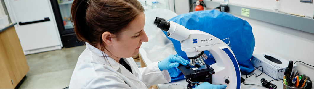 Women in a labratory working on a microscope
