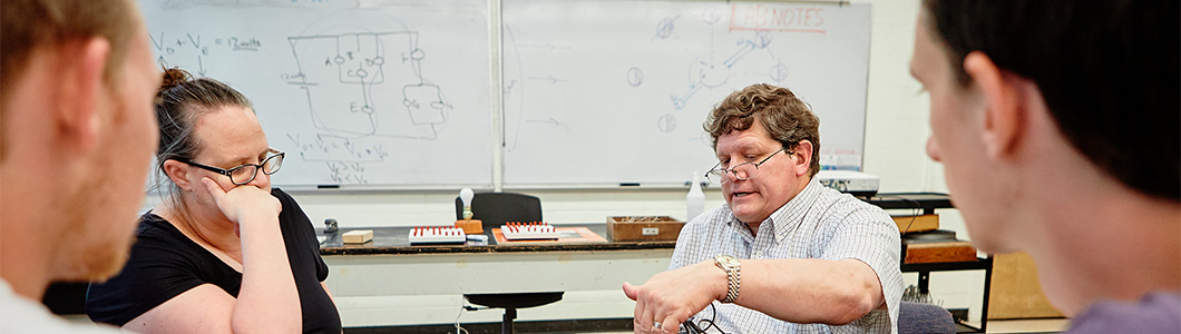 A professor is instructing a physics demostration.
