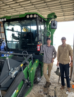 Trevor and Greg next to the combine in the shed at the post farm