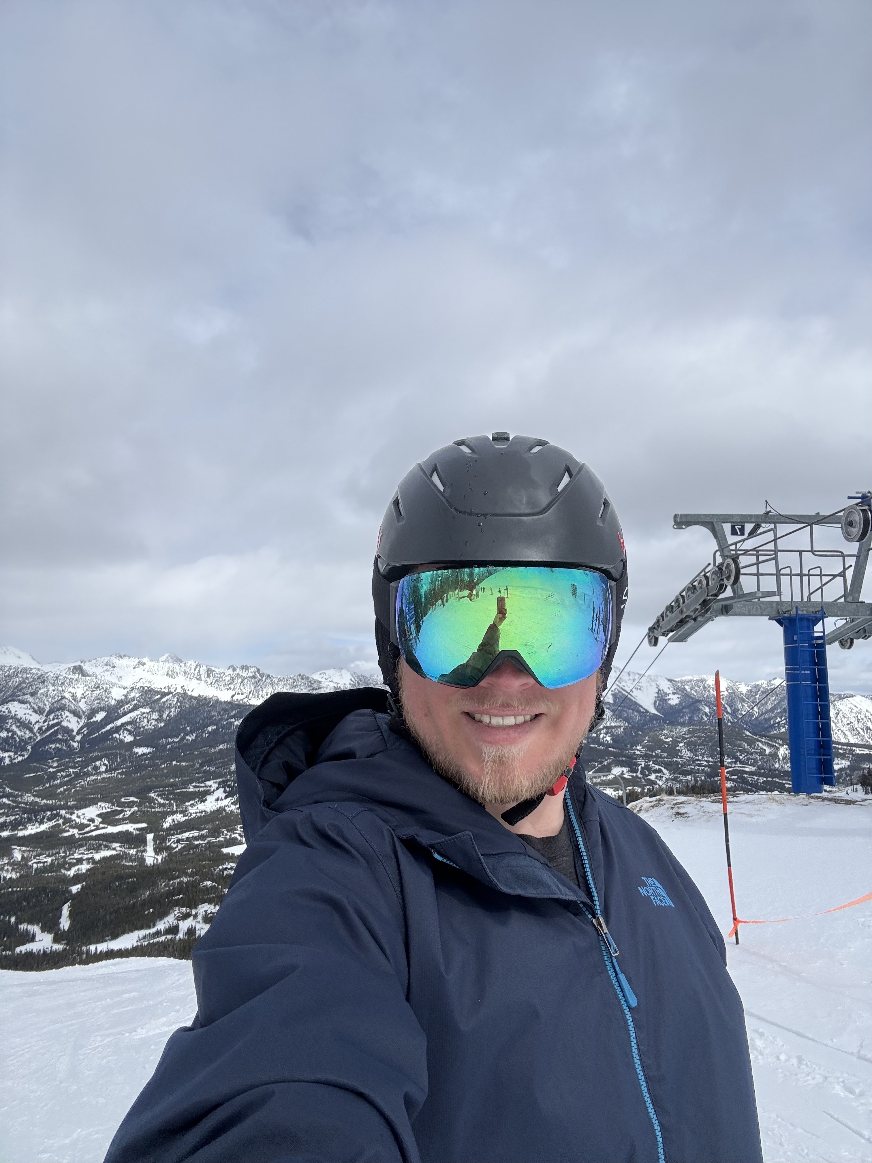 Konnor in ski gear with a ski lift in the background