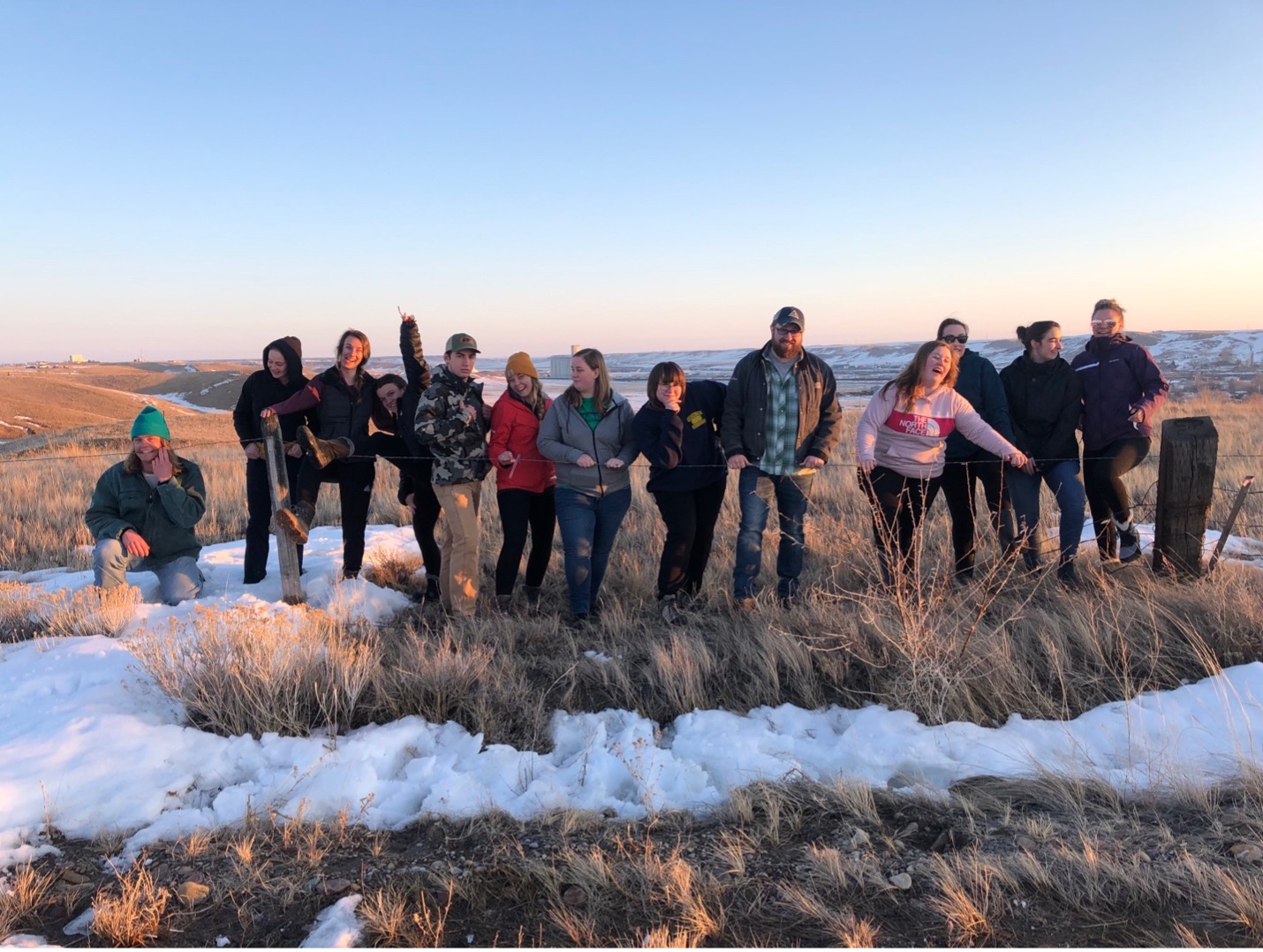 Rural practicum students pose for a photo in a grassy field