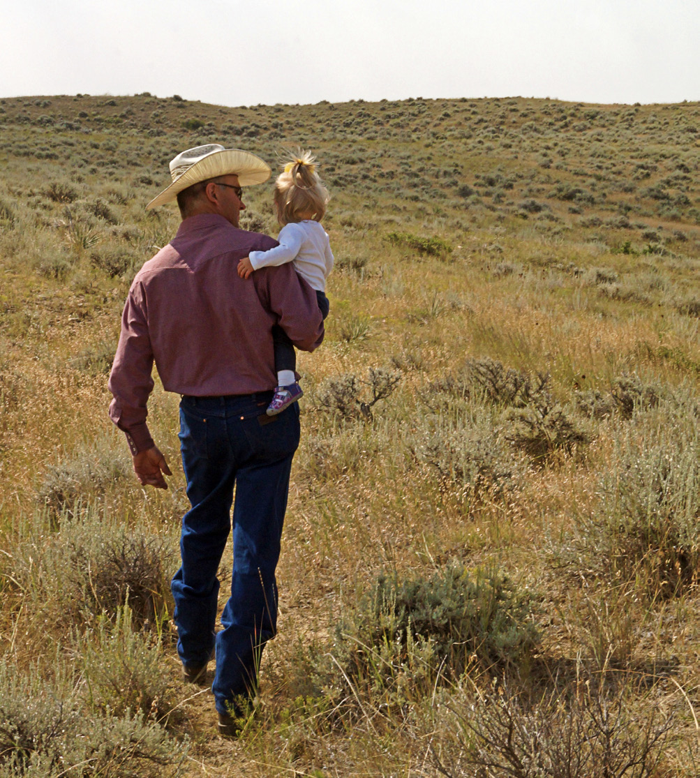 Cowboy in field with daughter