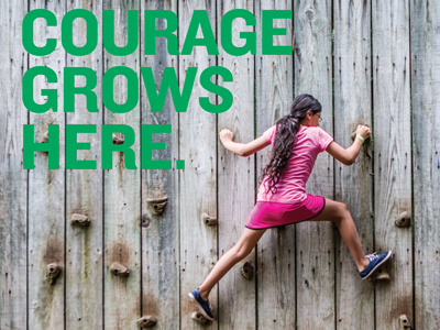 4-H member on a climbing wall with text next to her saying "Courage Grows Here"