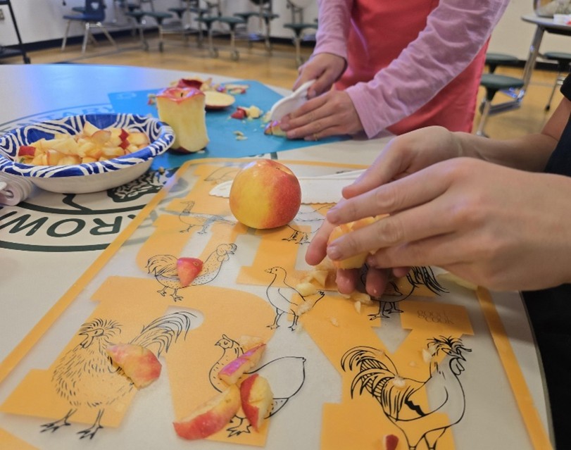 photo of youth practicing safe knife skills on fruit at a program at Arrowhead Elementary School
