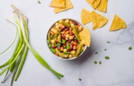 A bowl of 3 bean salad with chips.