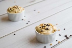 Two small bowls of banana swirl topped with chopped nuts and chocolate chips.