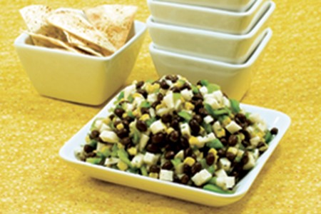 A bowl of Jicama and Black Bean Dip and a bowl of tortilla chips.