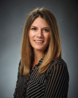 Portrait of a woman with brown hair and a black shirt smiling to the camera