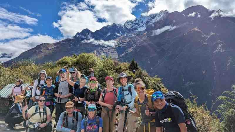 The group pauses for a photo with mountain views in the background.