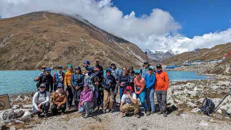 The group in front of a lake with the buildings of Gokyo in the distance.