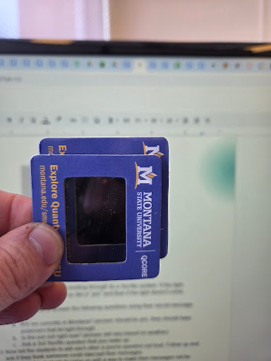 photo showing two polarizers held parallel to each other in front of a computer screen with no light passing through.