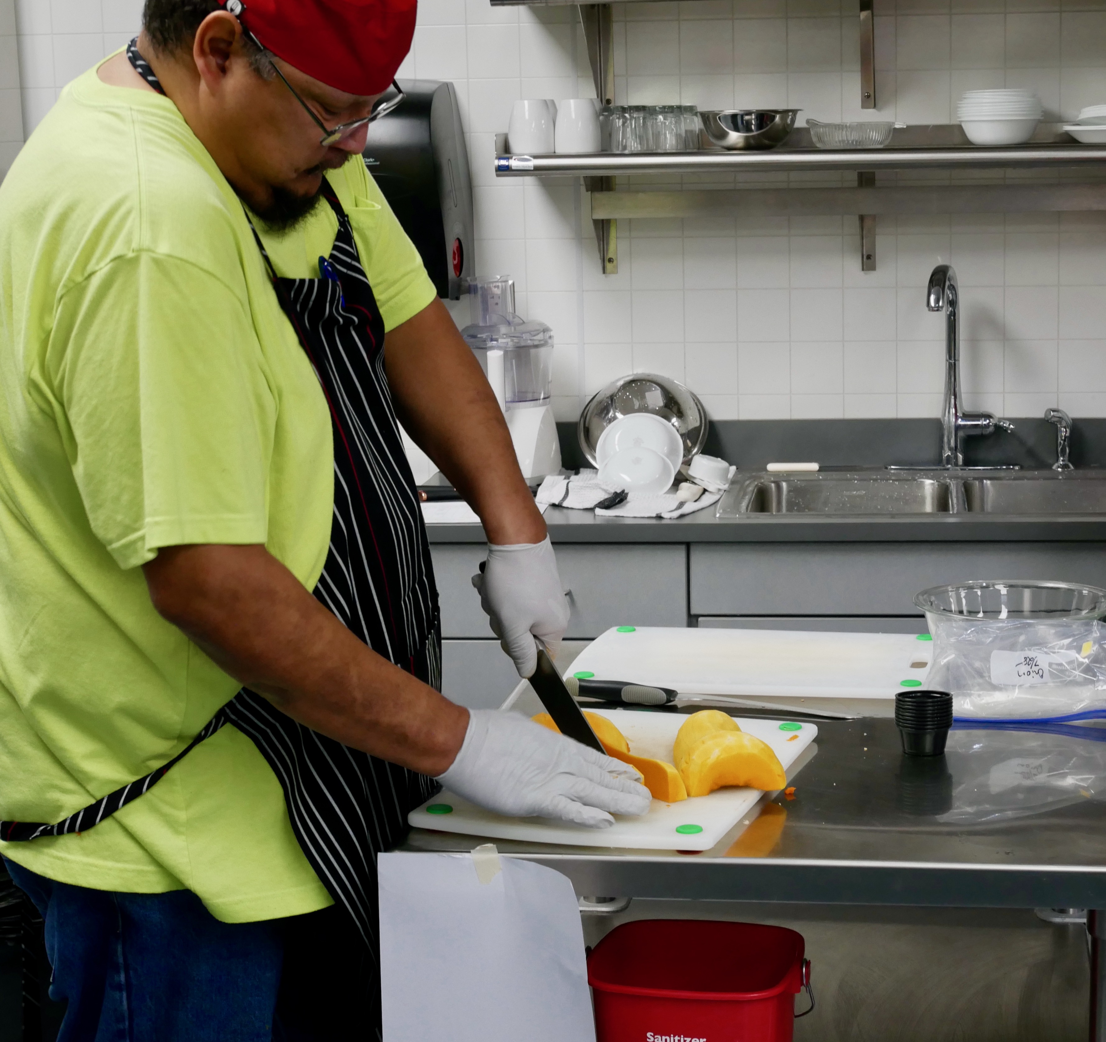 Scott Plainfeather demonstrates knife skills by slicing butternut squash